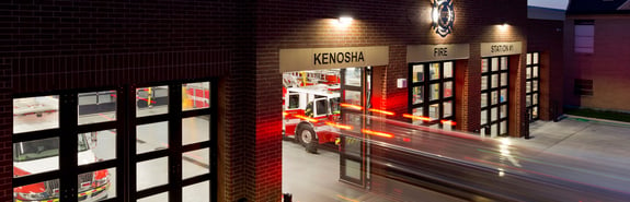 Fire station at night with fire engines leaving